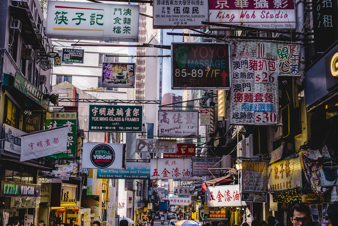 gallery-02 Vibrant urban street filled with numerous bright signs in Hong Kong, showcasing local businesses and culture.