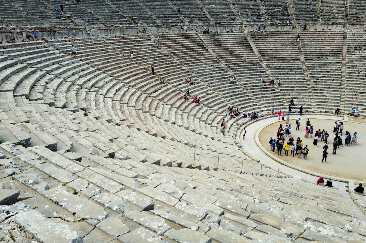 gallery-03 Tourists explore the ancient amphitheater showcasing historic architecture and cultural heritage.